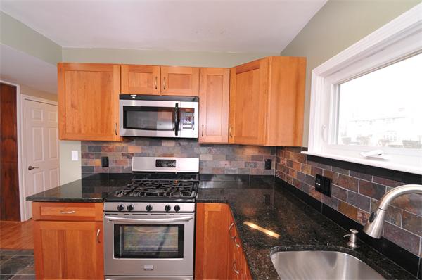 28 Hardwick Road Natick, MA 01760 - Photo 11 of 30 a kitchen with stainless steel appliances granite countertop a stove a sink and a microwave
