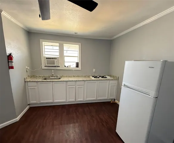 a view of a kitchen with a sink dishwasher a refrigerator and wooden floor