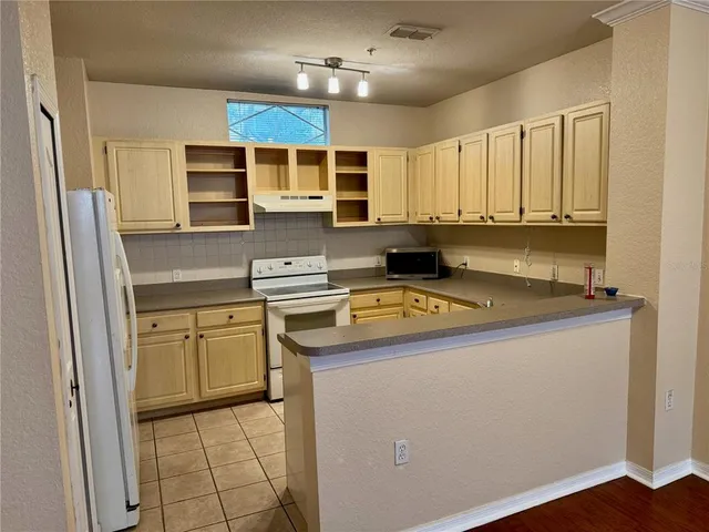 a kitchen with stainless steel appliances granite countertop a sink and a refrigerator