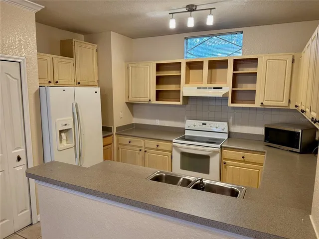 a kitchen with stainless steel appliances a stove refrigerator sink and cabinets