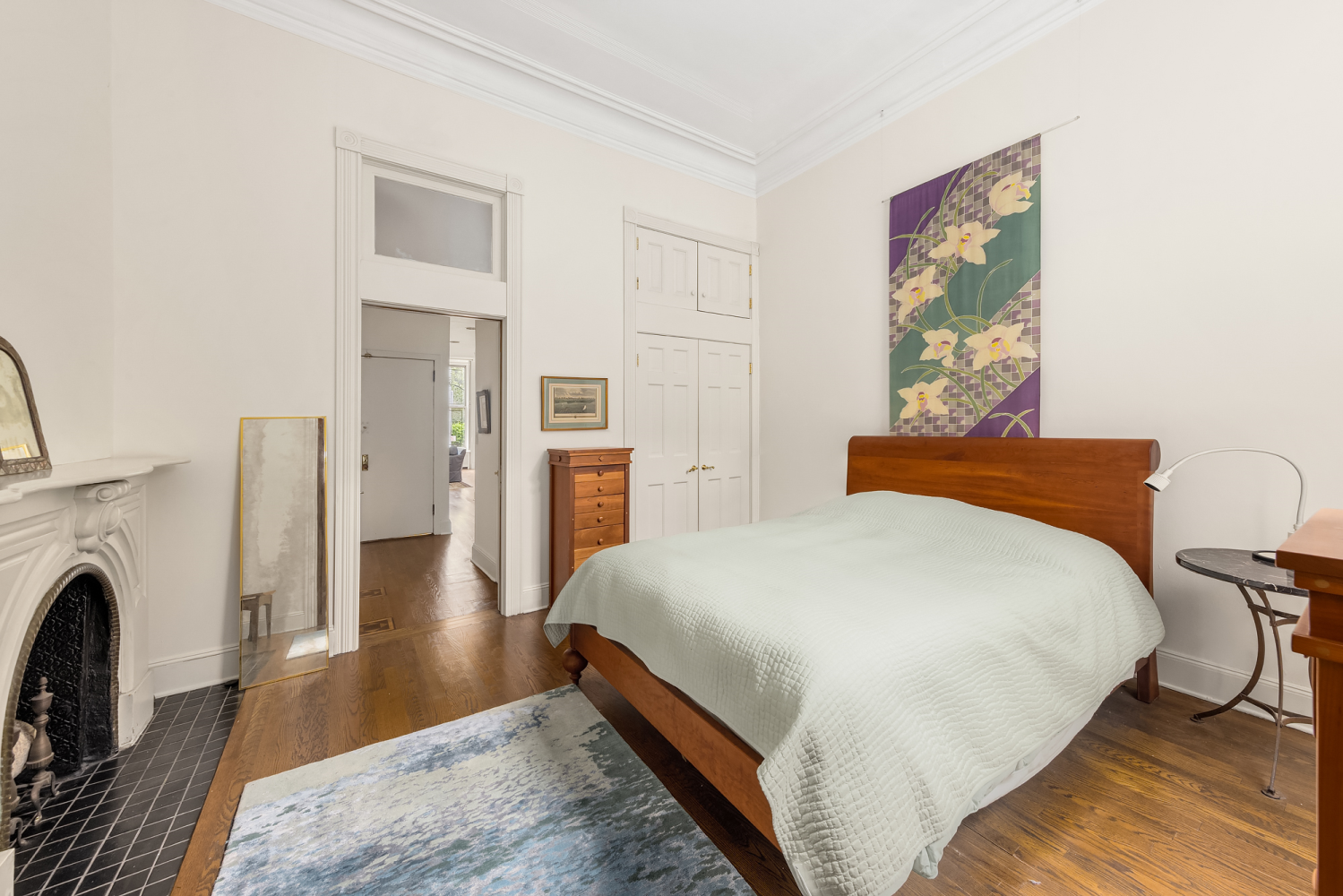 48 East 83rd Street, Unit GARDEN Manhattan, NY 10028 - Photo 8 of 16 a bedroom with a bed a table and wooden floor