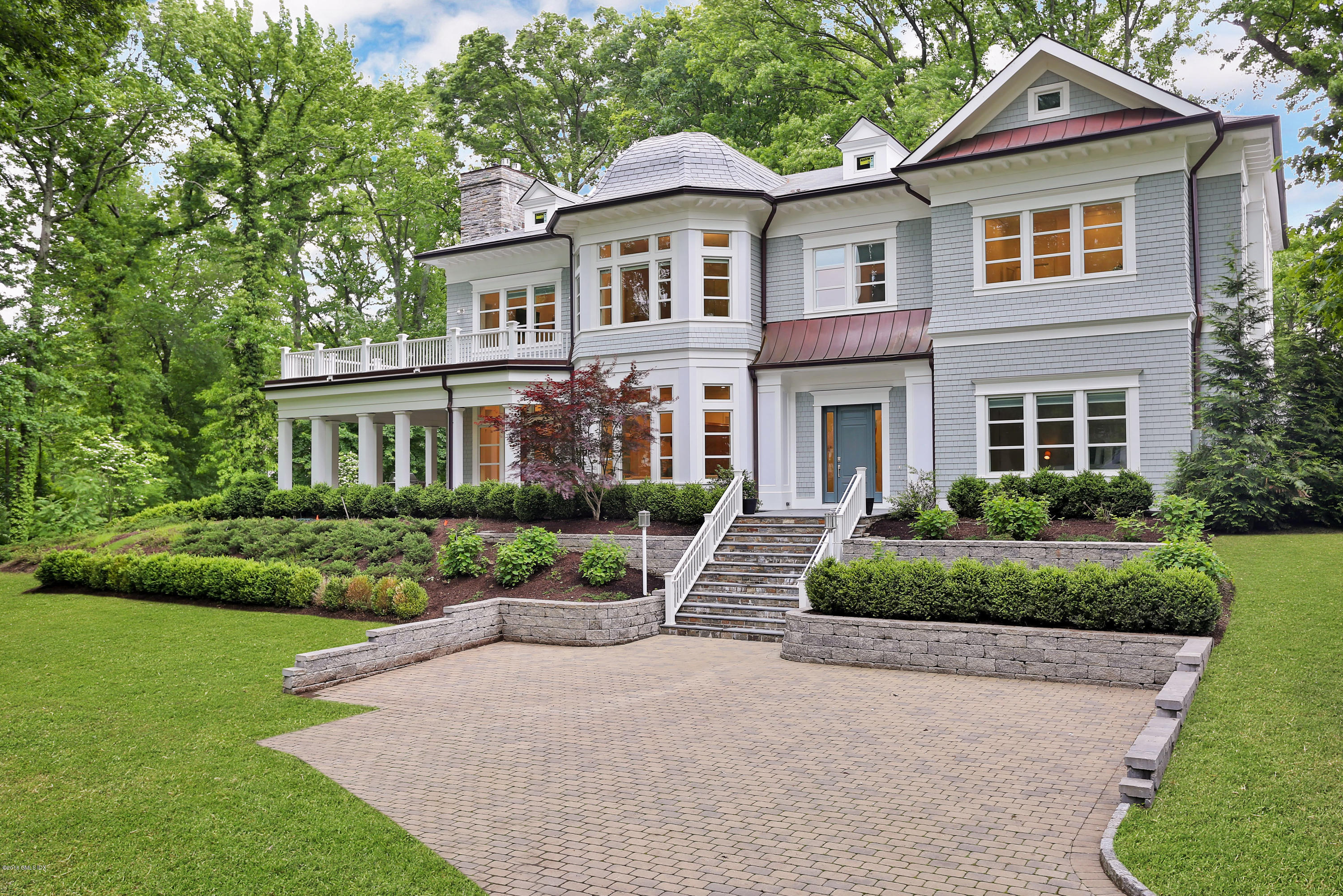 a front view of a house with a yard and green space