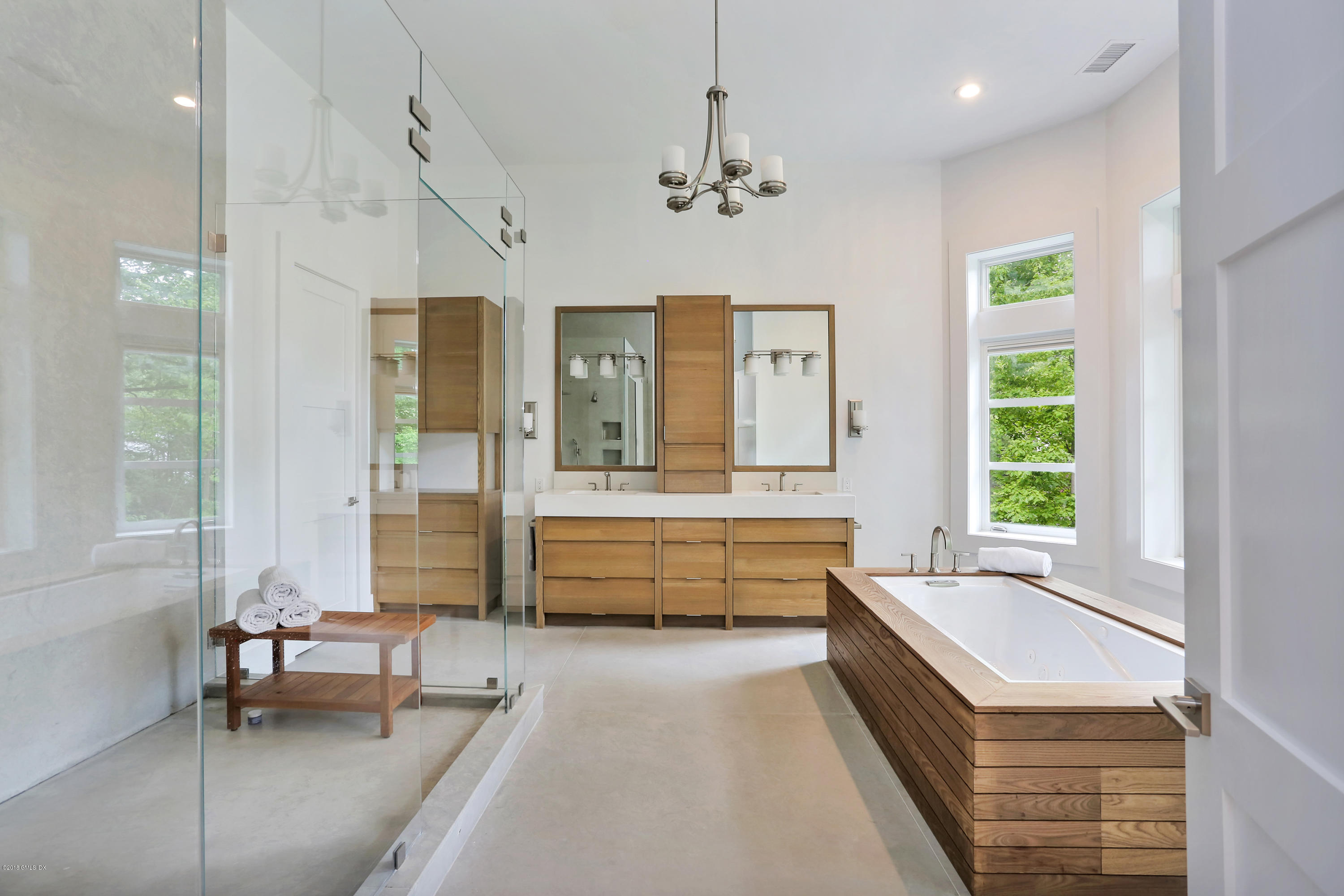 22 Oak Drive Riverside, CT 06878 - Photo 17 of 32 a bathroom with a tub a double vanity sink and a large mirror