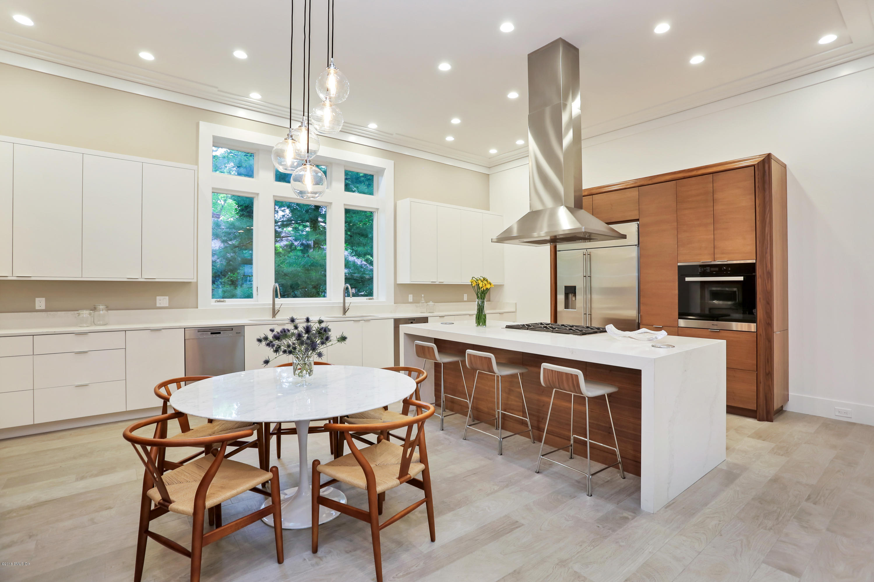 22 Oak Drive Riverside, CT 06878 - Photo 6 of 32 a kitchen with stainless steel appliances a dining table chairs stove and white cabinets