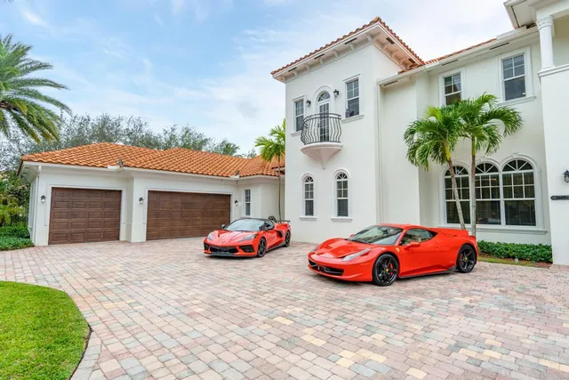 a kitchen with stainless steel appliances kitchen island granite countertop a refrigerator a oven and white cabinets with wooden floor