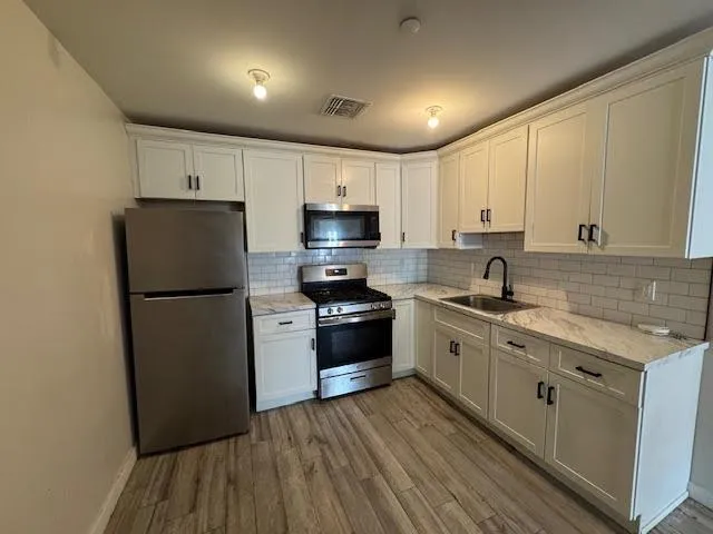 a kitchen with stainless steel appliances a refrigerator stove and sink