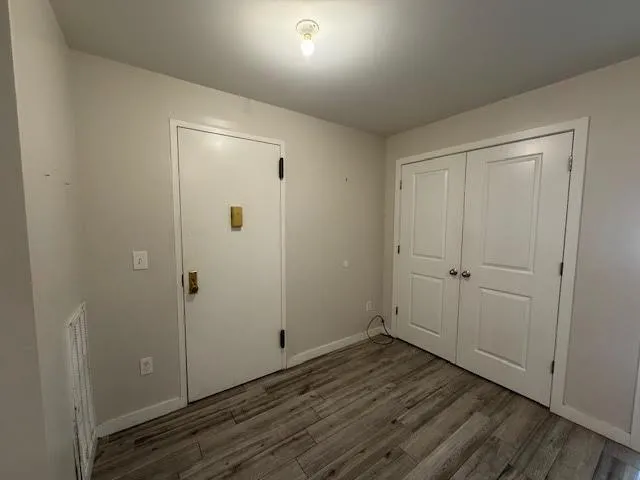 a view of an empty room with wooden floor