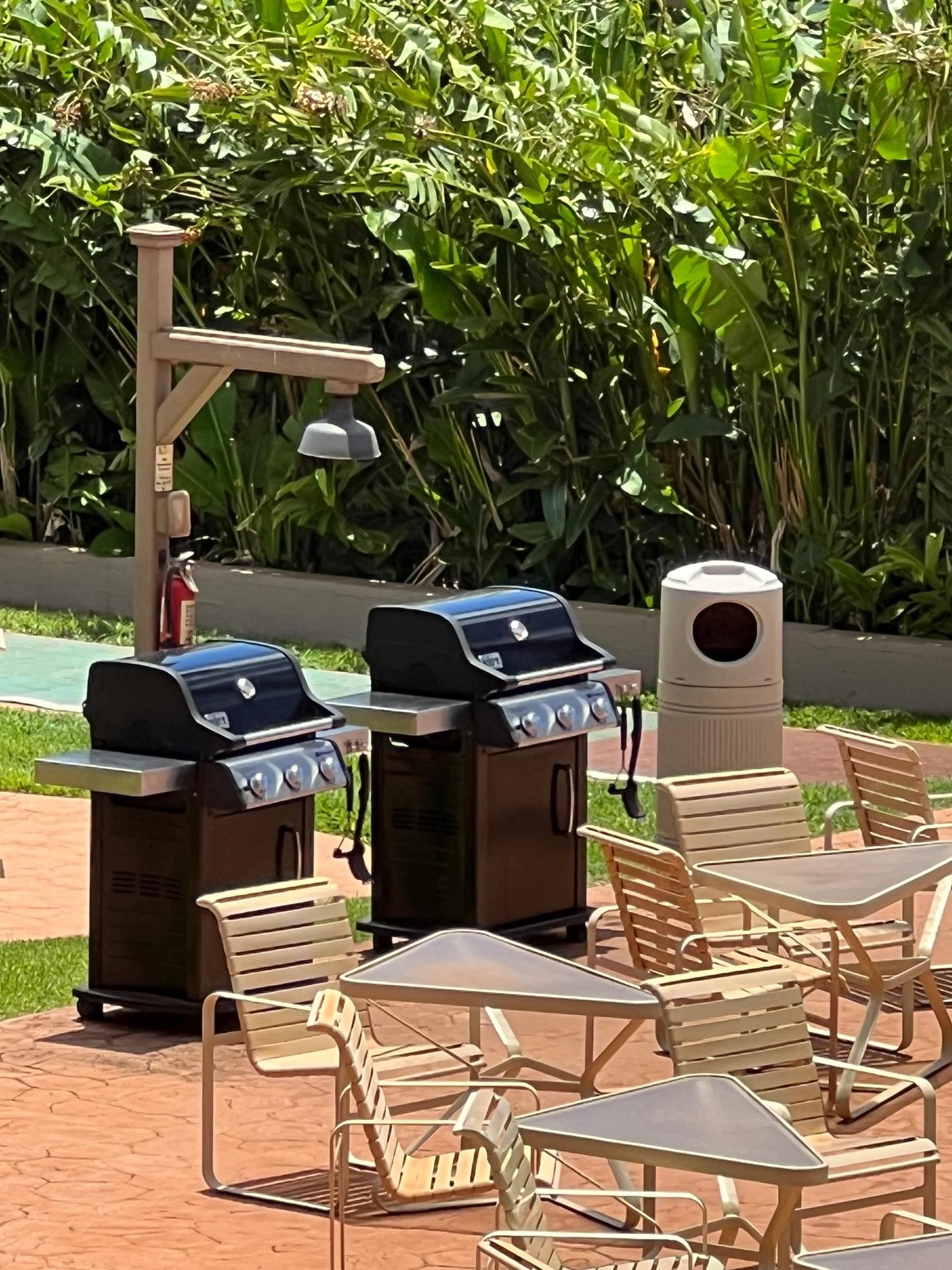 3823 Lower Honoapiilani Road, Unit 211 Lahaina, HI 96761 - Photo 21 of 34 a view of a patio with table and chairs and a barbeque