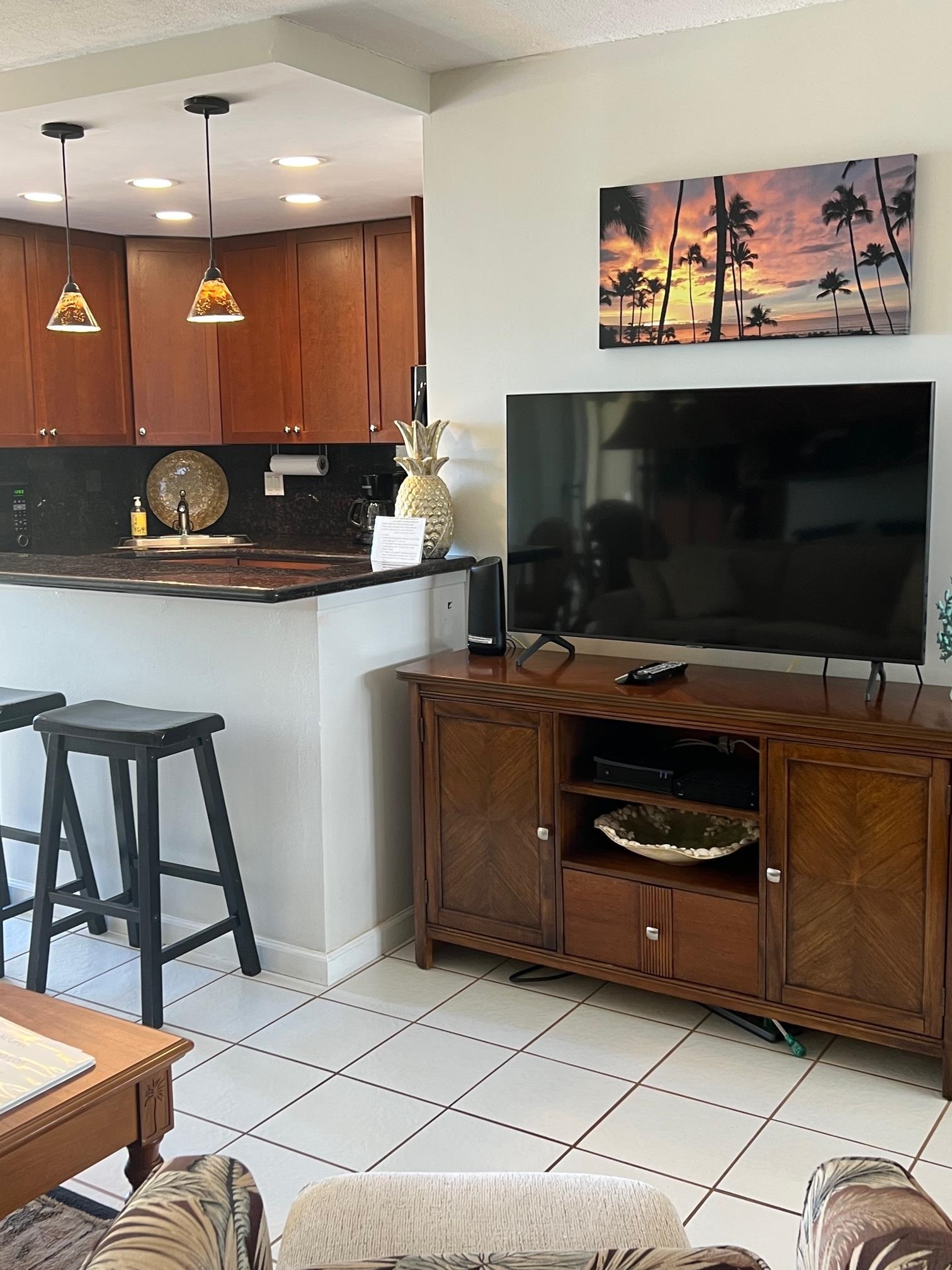3823 Lower Honoapiilani Road, Unit 211 Lahaina, HI 96761 - Photo 10 of 34 a kitchen with stainless steel appliances kitchen island granite countertop a stove and a microwave