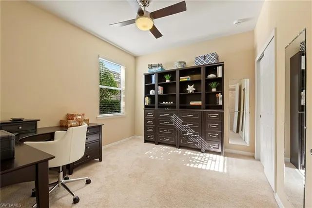 a view of a workspace with furniture and a window