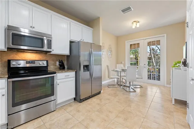 a kitchen with granite countertop a refrigerator and a stove top oven