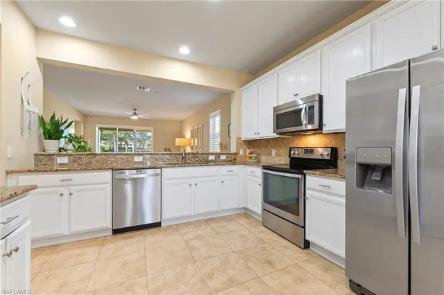 a kitchen with granite countertop cabinets stainless steel appliances and a counter space