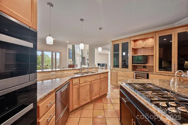 a large kitchen with cabinets stove top oven and sink