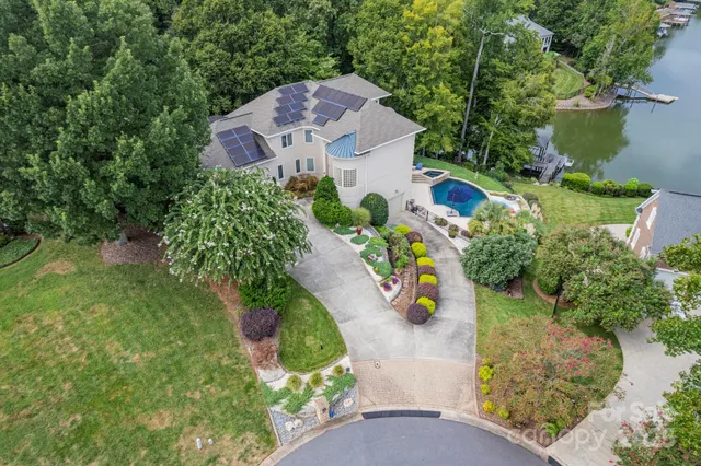 an aerial view of a house with a yard and lake view