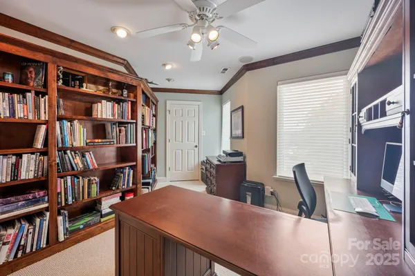 a view of a workspace with furniture bookshelf and a window