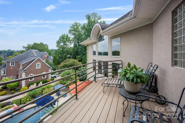 a house with wooden floor outdoor seating and yard in the back