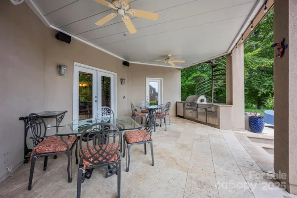 a view of a patio with table and chairs potted plants with floor to ceiling window and potted plants