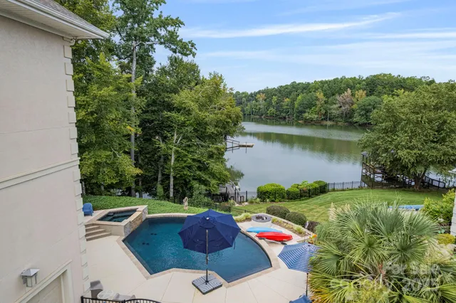 a view of backyard with seating space and trees in the background