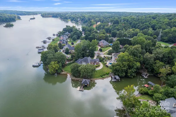an aerial view of a house with a yard and lake view