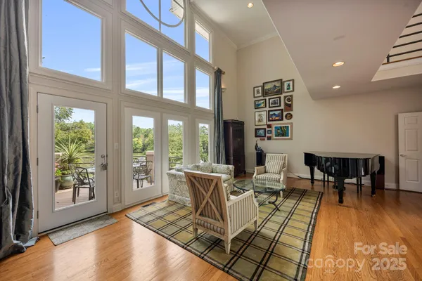 a living room with furniture floor to ceiling window and wooden floor