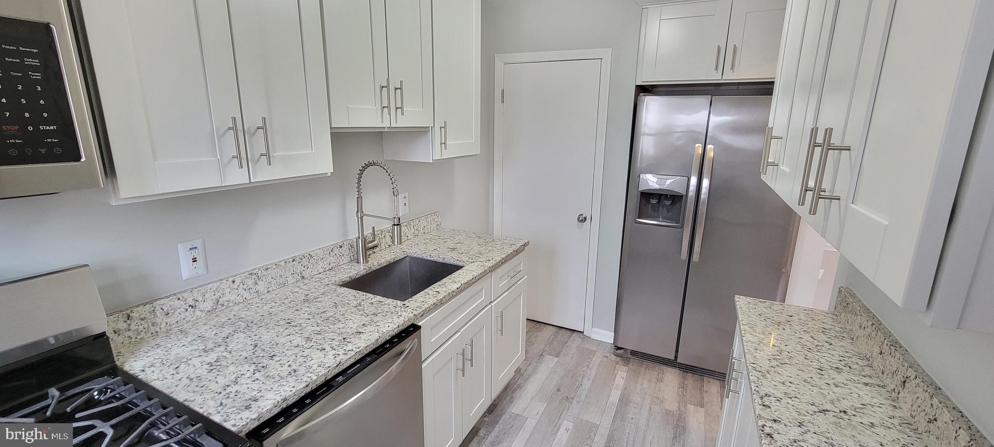 452 Westfield Road Dundalk, MD 21222 - Photo 11 of 34 a kitchen with granite countertop a sink stove and refrigerator