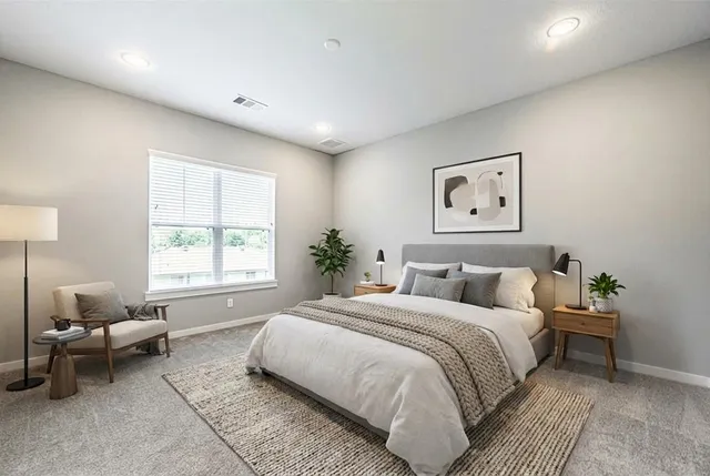 a bedroom with a large bed and a window