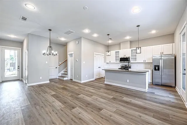 a large kitchen with stainless steel appliances kitchen island a stove a refrigerator a sink and a oven