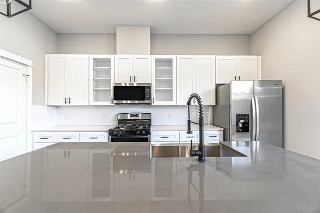 a kitchen with stainless steel appliances a refrigerator a stove a microwave and sink