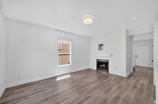 14771 Haddington Road Draper, UT 84020 - Photo 6 of 44 Living area featuring wood-finish flooring, a contemporary fireplace with a shiplap accent wall, and a built-in mantel