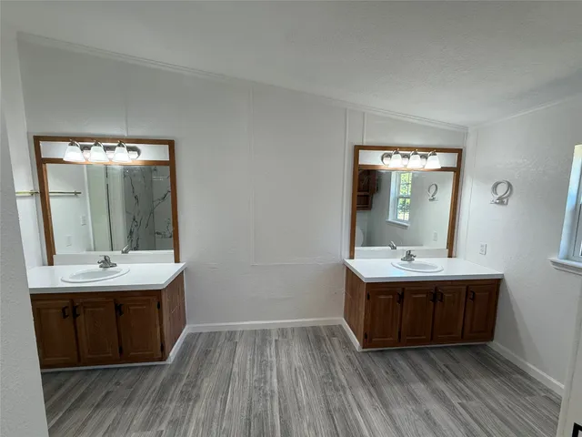 a view with a sink and mirror with wooden floor