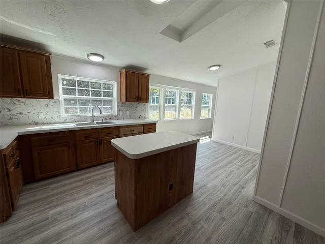 a kitchen with a sink and wooden floor