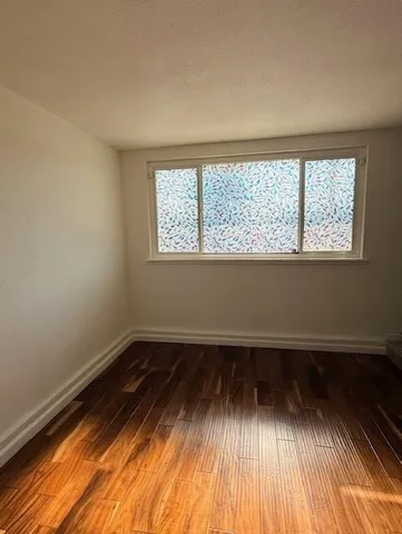a view of a room with wooden floor and window