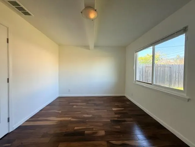 a view of an empty room with wooden floor