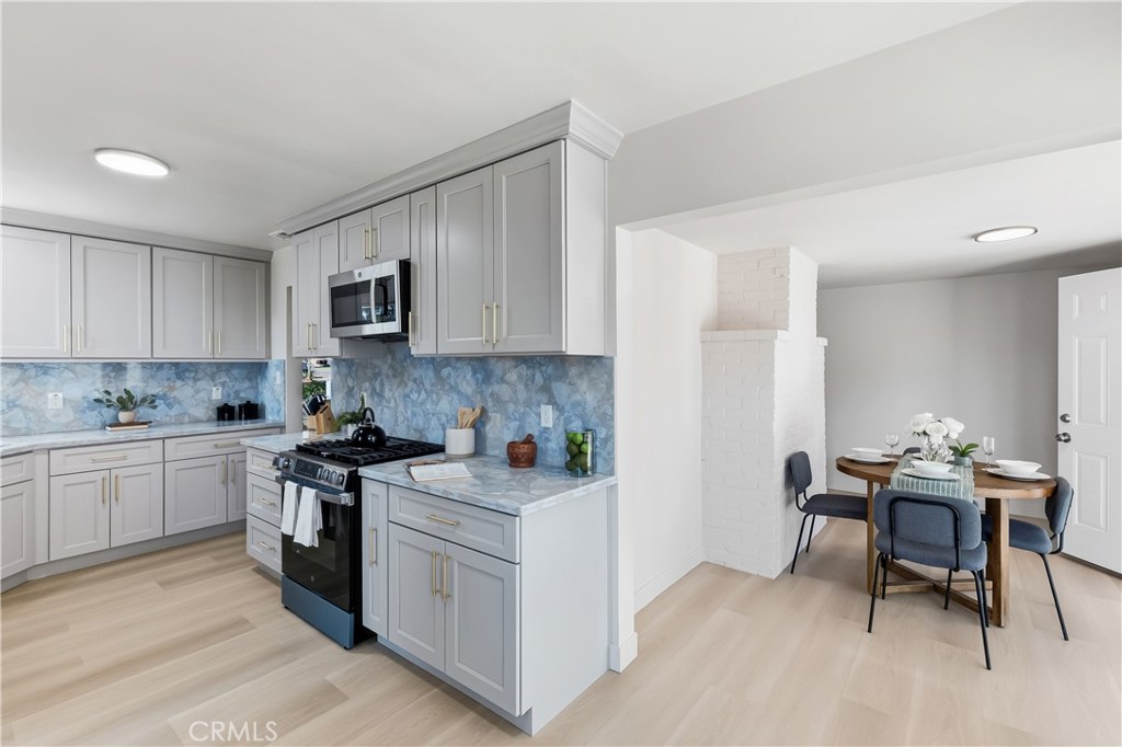 3328 North Verdugo Road Glendale, CA 91208 - Photo 13 of 42 a kitchen with stainless steel appliances granite countertop a stove top oven a sink dishwasher and white cabinets with wooden floor