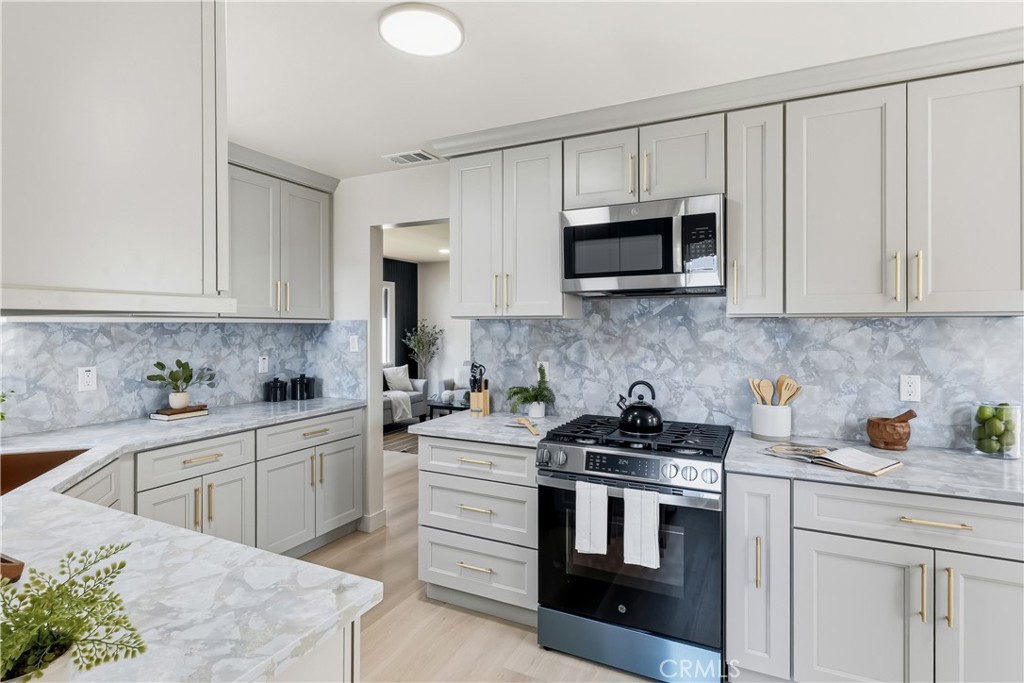 3328 North Verdugo Road Glendale, CA 91208 - Photo 14 of 42 a kitchen with stainless steel appliances granite countertop white cabinets a stove a microwave and a sink