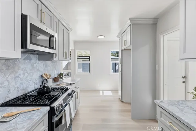 a kitchen with stainless steel appliances granite countertop a stove and a microwave