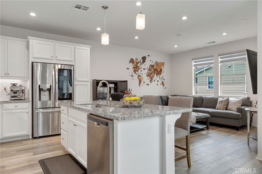 a kitchen with stainless steel appliances granite countertop sink refrigerator and microwave