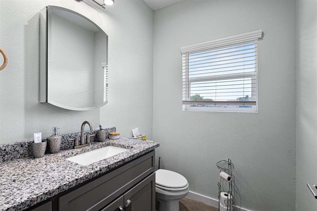 124 County Road 4511 Decatur, TX 76234 - Photo 11 of 39 a bathroom with a granite countertop sink a toilet and mirror