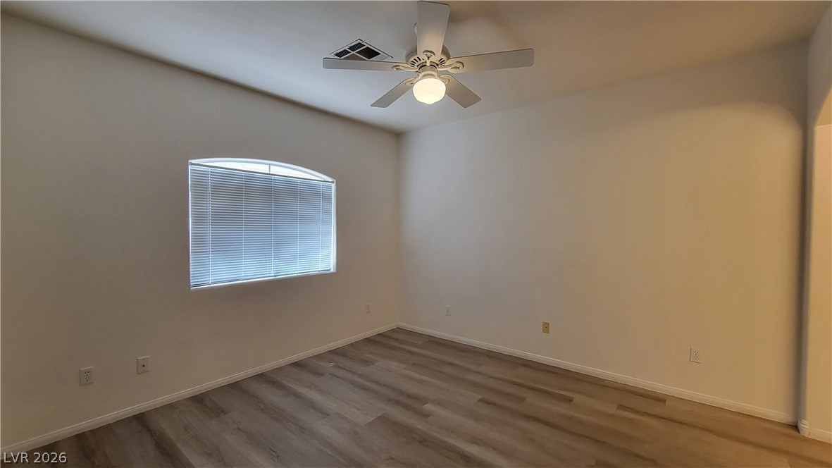 3320 South Fort Apache Road, Unit 111 Las Vegas, NV 89117 - Photo 5 of 12 A well-lit bedroom with durable wood flooring and a refreshing ceiling fan.