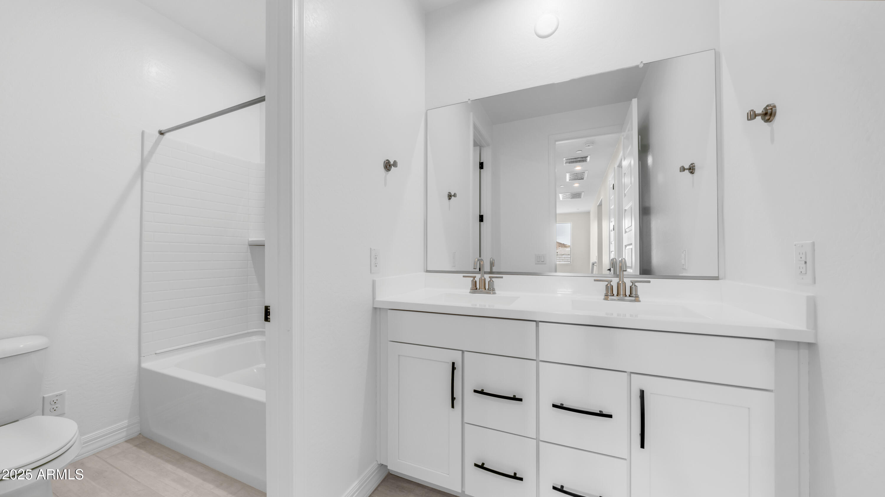 13359 West Eagle Feather Road Peoria, AZ 85383 - Photo 24 of 33 a bathroom with a double vanity sink toilet mirror and bathtub