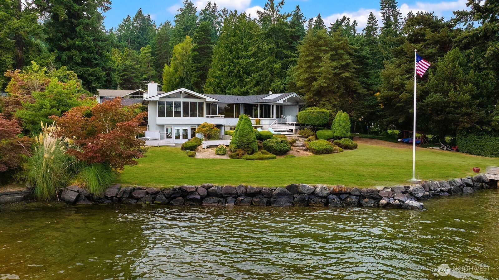 4802 East Mercer Way Mercer Island, WA 98040 - Photo 3 of 33 a front view of a house with a yard and lake view