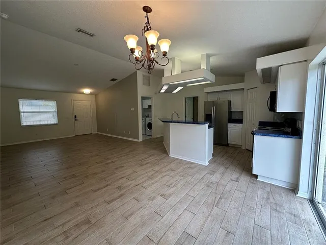 a view of a room with wooden floor and a ceiling fan