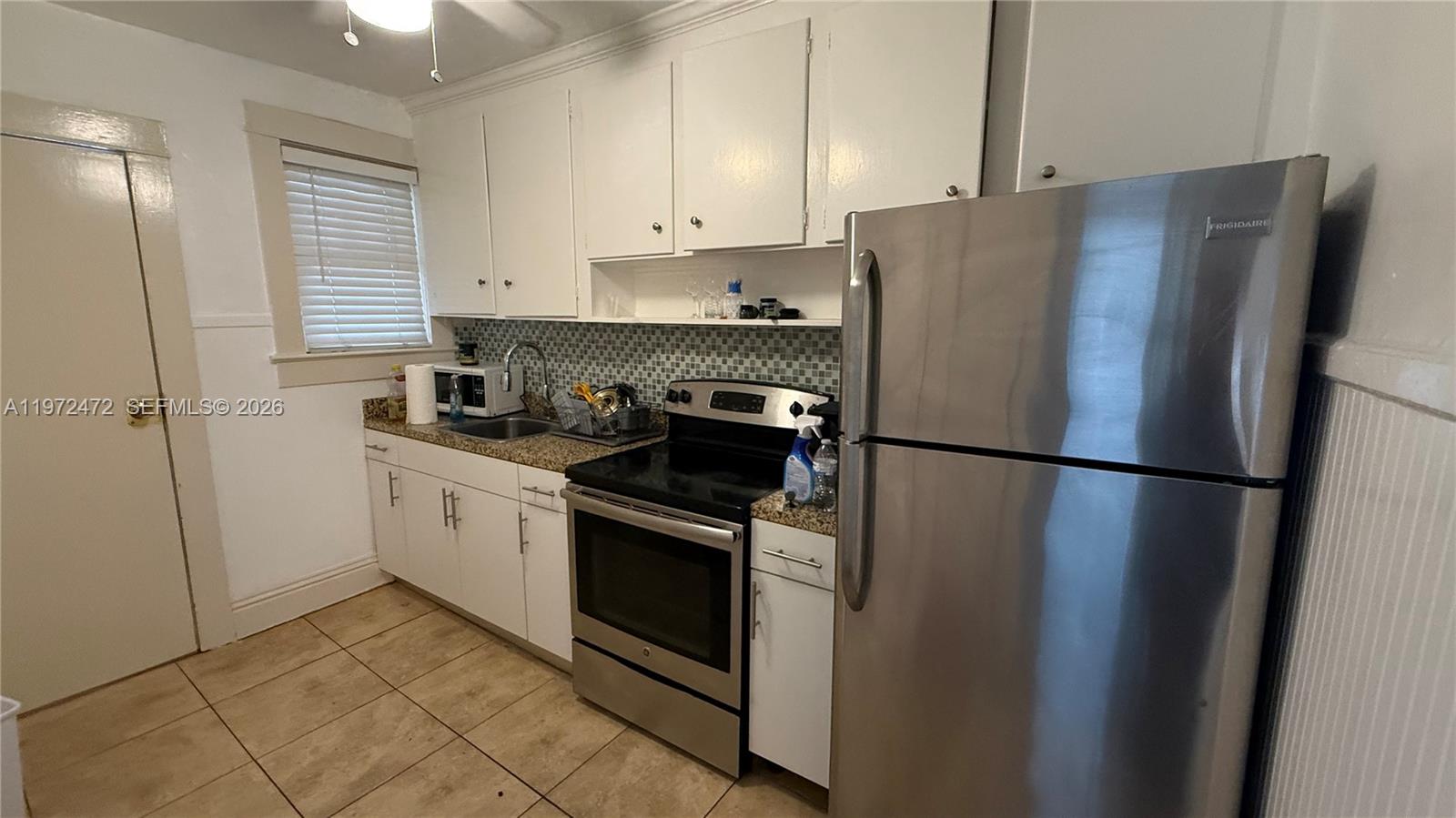 2153 Southwest 14th Terrace, Unit 4 Miami, FL 33145 - Photo 5 of 14 a kitchen with a refrigerator sink and cabinets