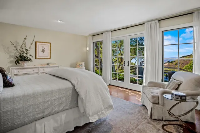 a spacious bedroom with a bed and glass window