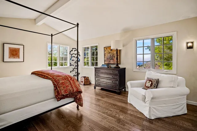 a spacious bedroom with a bed a couch and a window