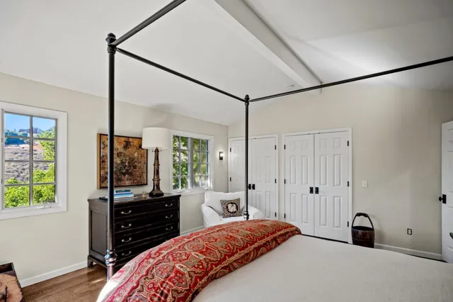 a bedroom with a bed and a flat tv screen on the dresser