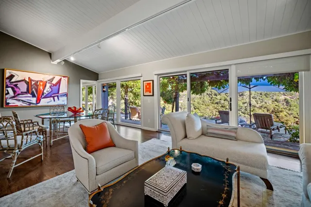 a living room with furniture and a floor to ceiling window