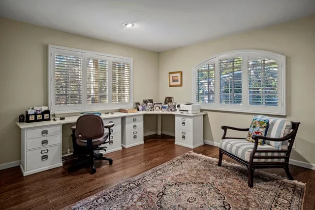 a view of a workspace with furniture and a window