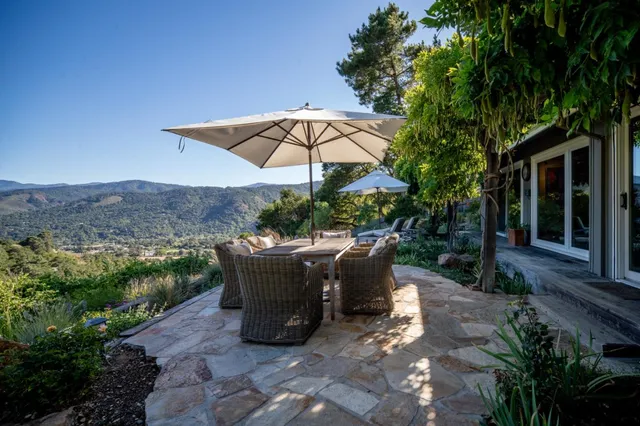 a view of a patio with table and chairs under an umbrella