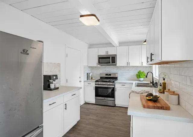 a kitchen with stainless steel appliances a stove sink microwave and cabinets